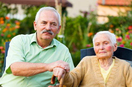 Elderly man and woman holding hands.